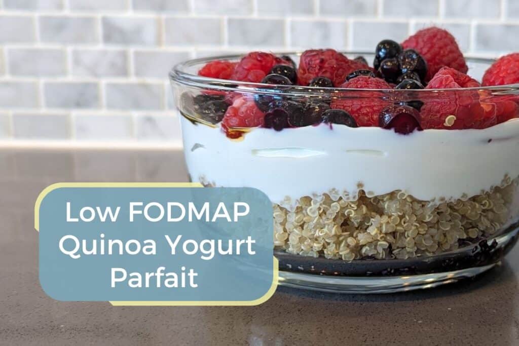 Glass bowl containing low fodmap quinoa yogurt parfait with berries