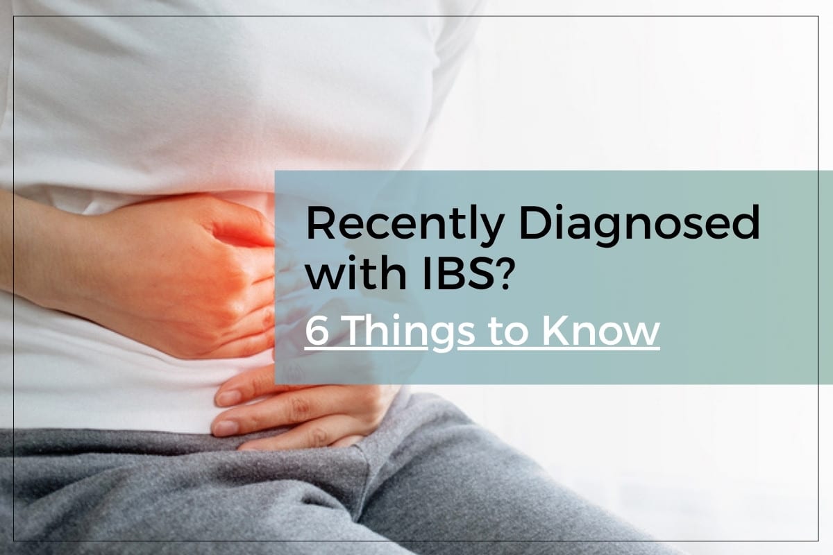 Woman with IBS holding her stomach in pain.